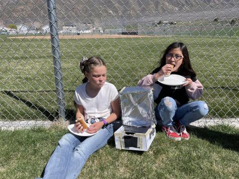 Some students eating the hotdogs they cooked in solar oven