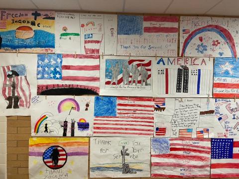 Posters were hung in the school hallway to honor thirteen fallen soldiers